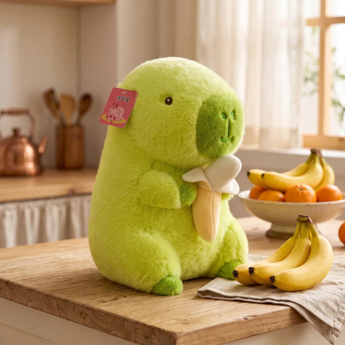 Banana capybara plush on a kitchen counter next to a bowl of fruit and fresh bananas