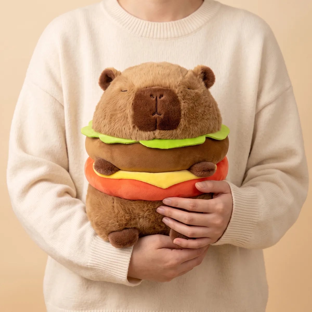 Person hugging the capybara burger plush against a sweater