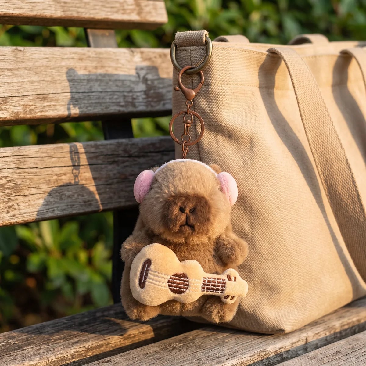 Guitar capybara keychain clipped onto a tote bag