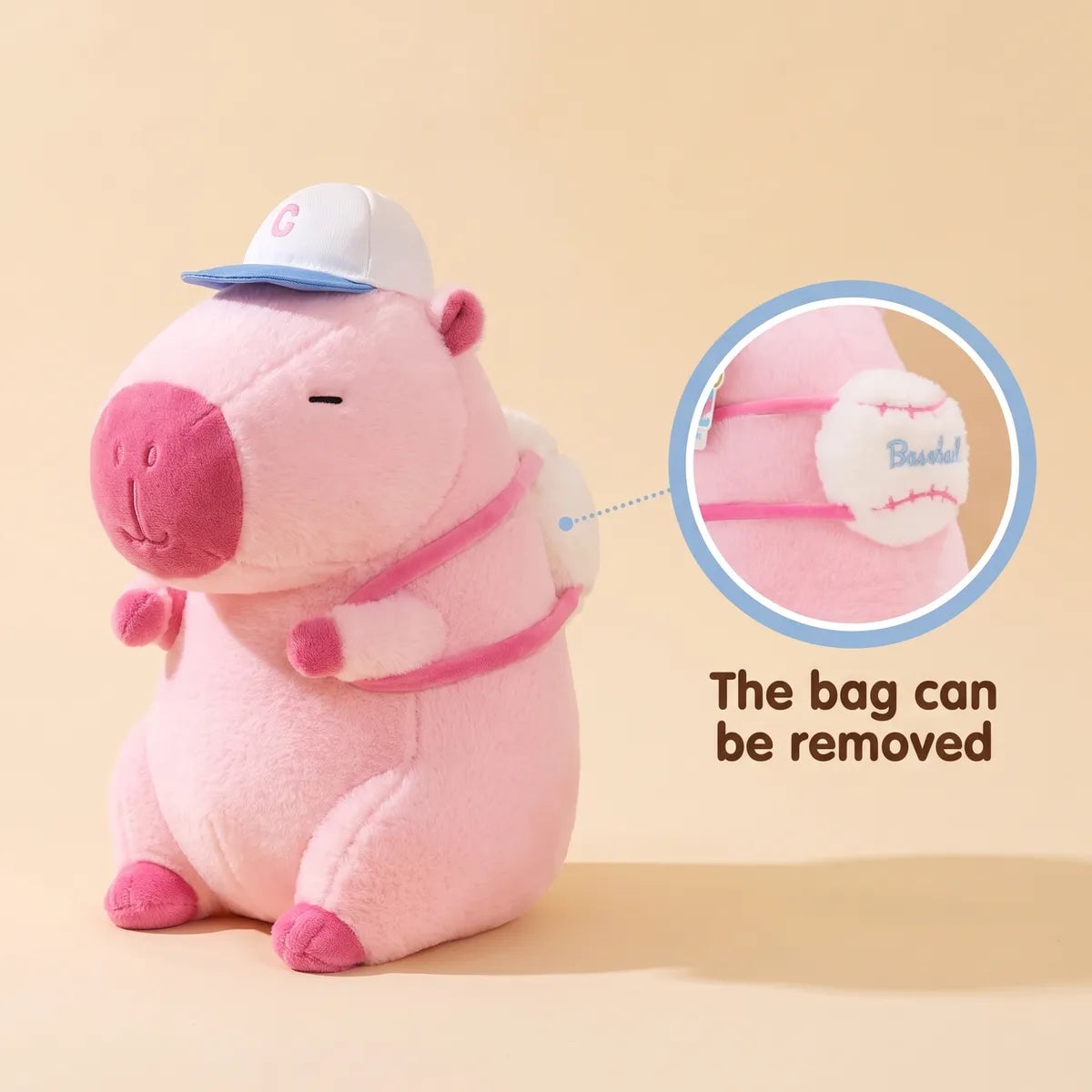 Pink capybara plush with its cap and the removable baseball backpack shown in close up