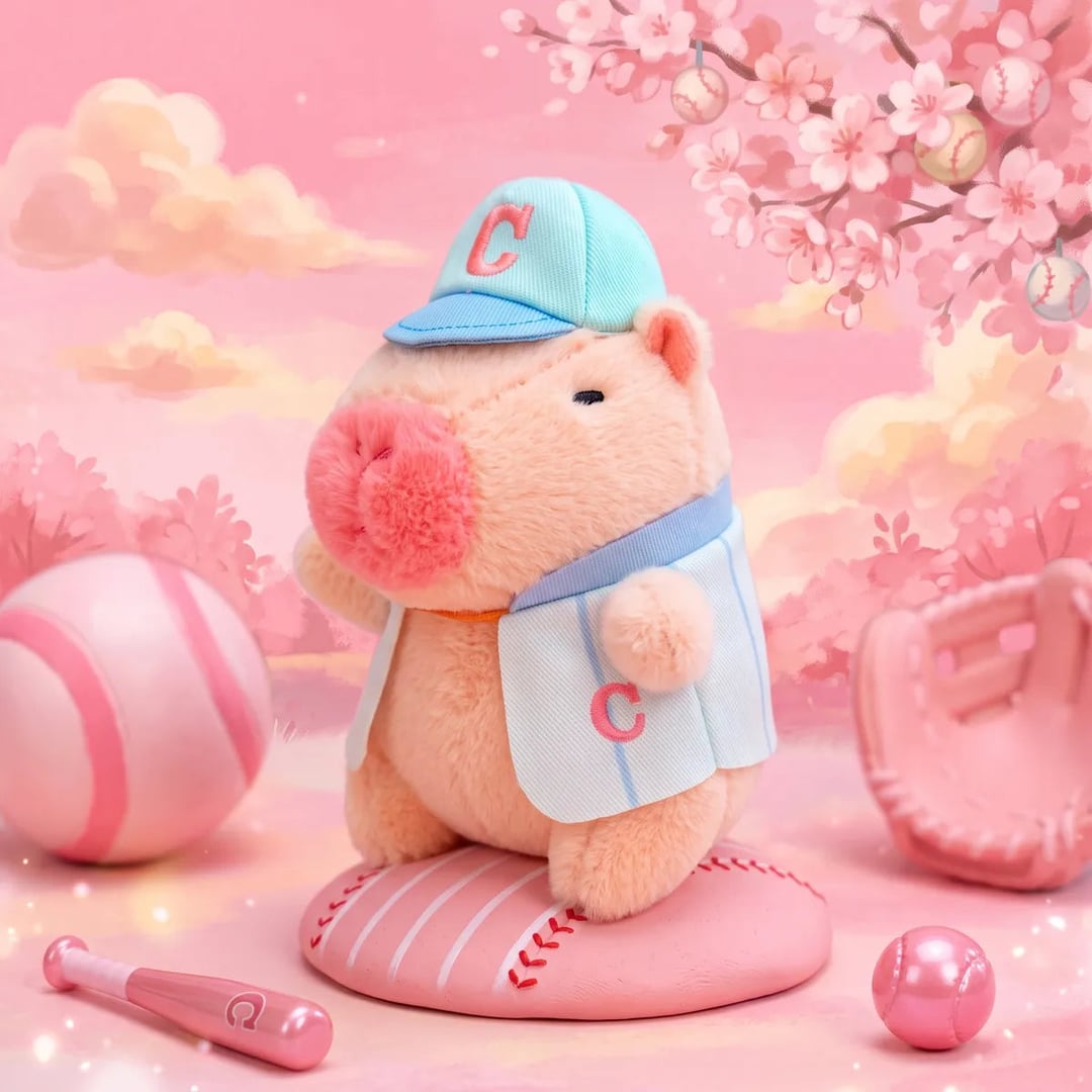 Pink baseball mini capybara plush in a blue cap on a home plate base under cherry blossom