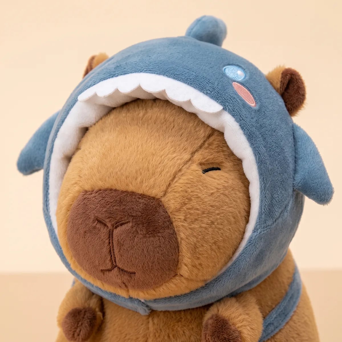 Close up of the felt teeth and side fins on the shark hood of the capybara plush